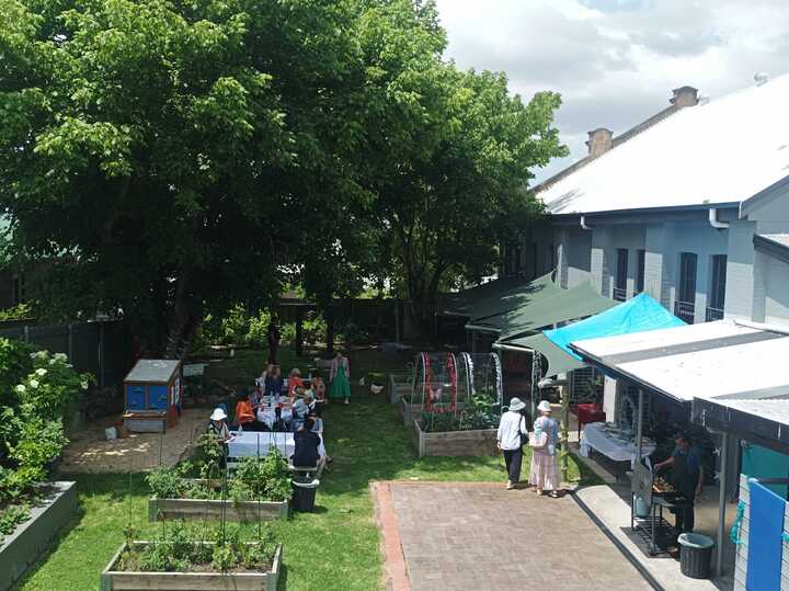 The Rozelle courtyard from above, with raised garden beds, a marquee and people gathered around long tables