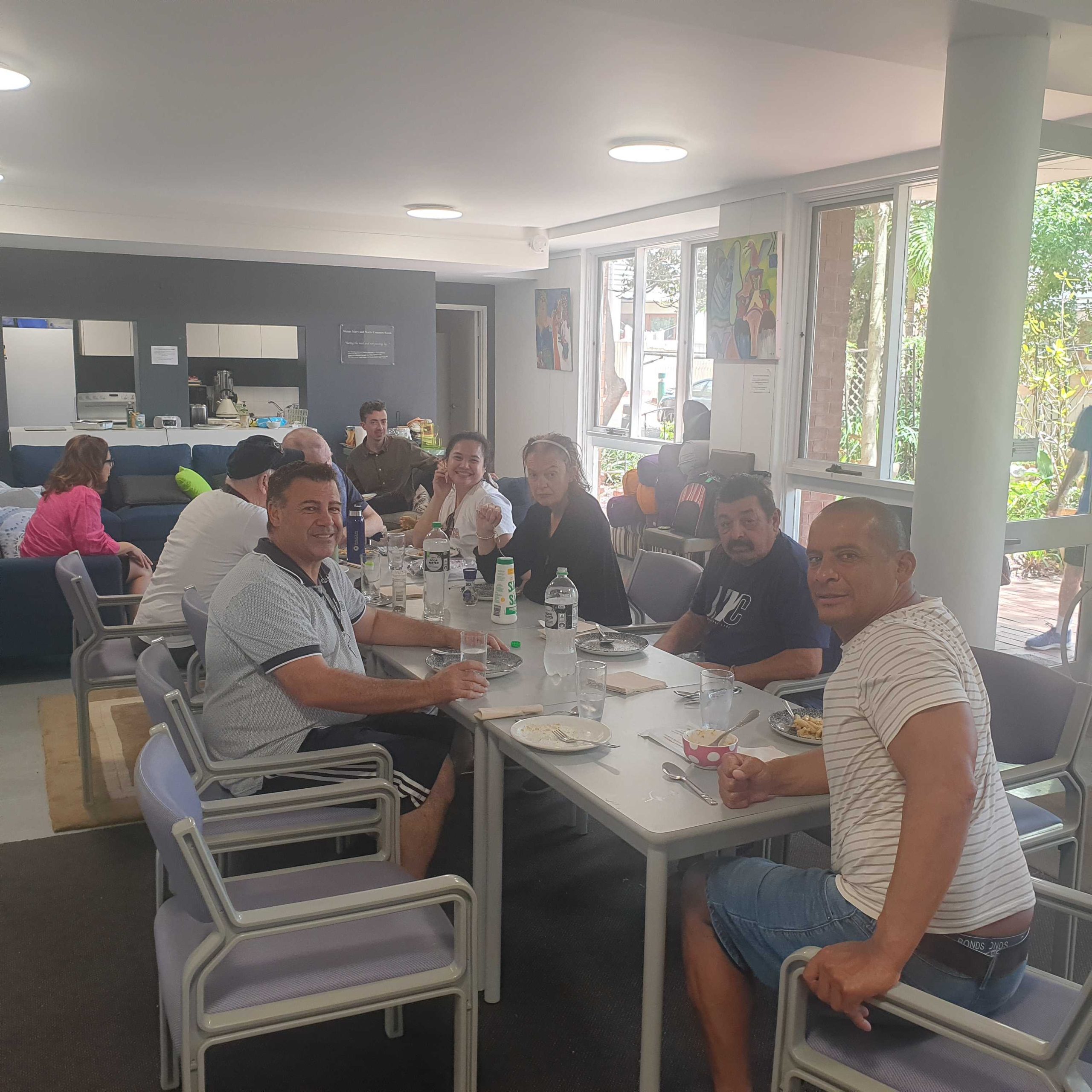 People sharing a meal at long tables in a community hall