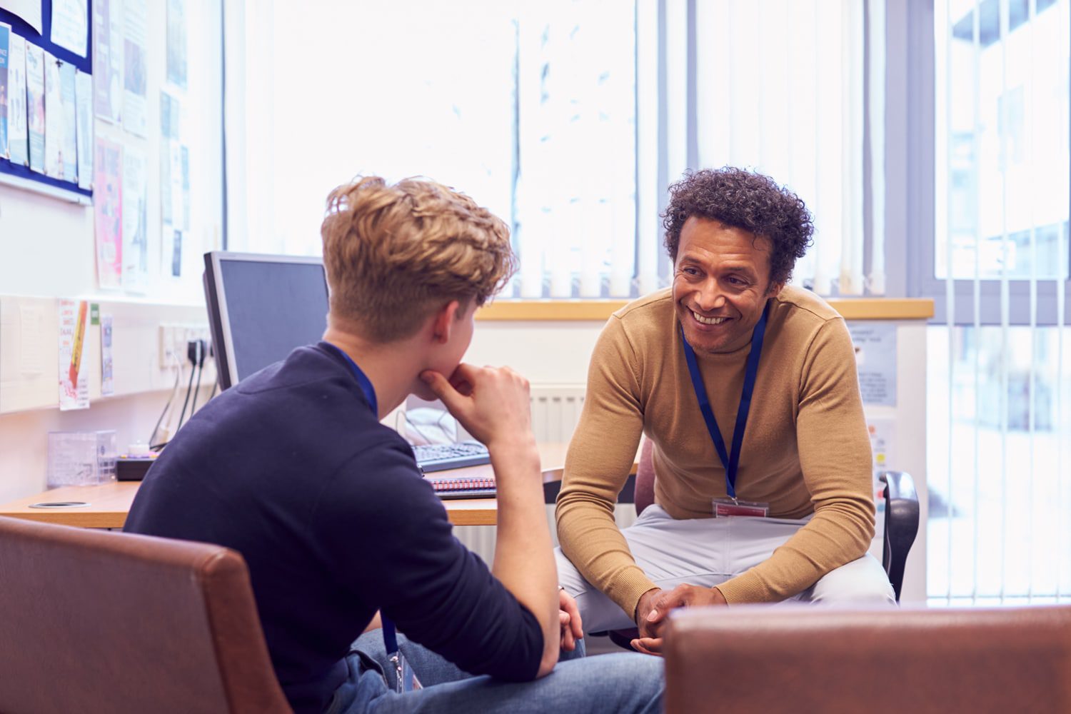 Two men talking across a desk in an office