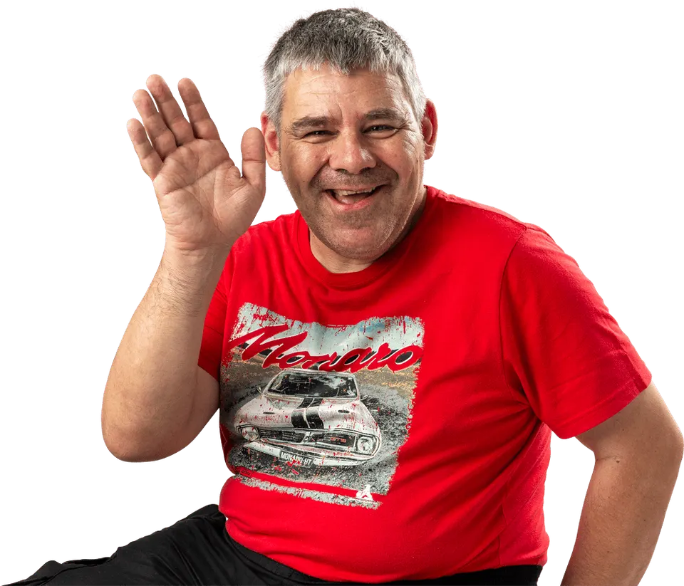 A smiling man in a red t-shirt waving hello