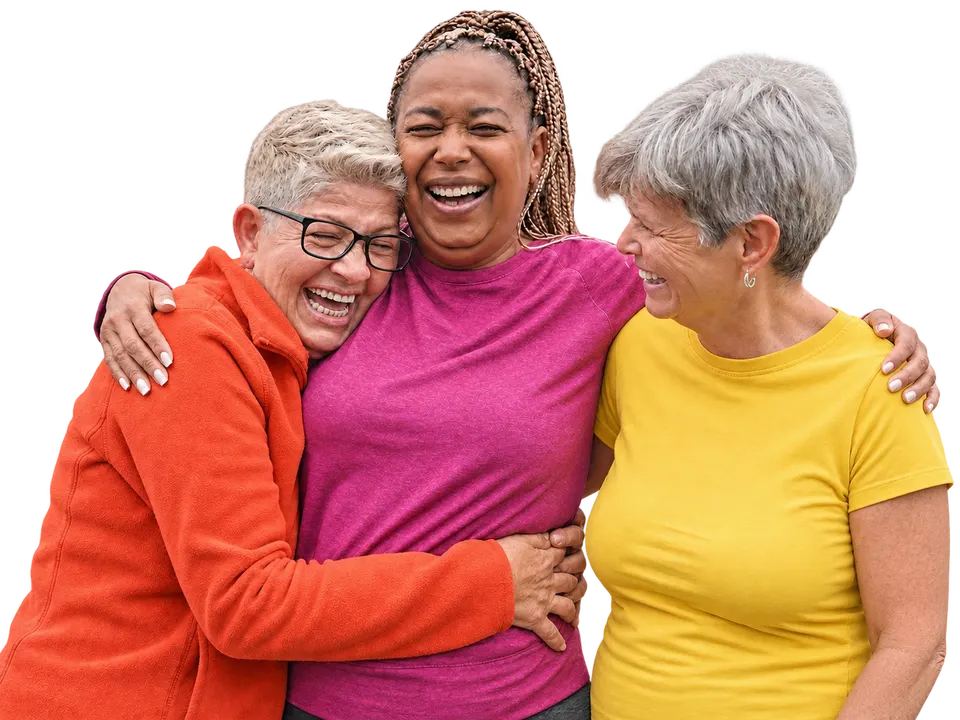 Three women laughing together, arms around each other