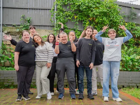 A group of together² staff and participants smiling together in the garden