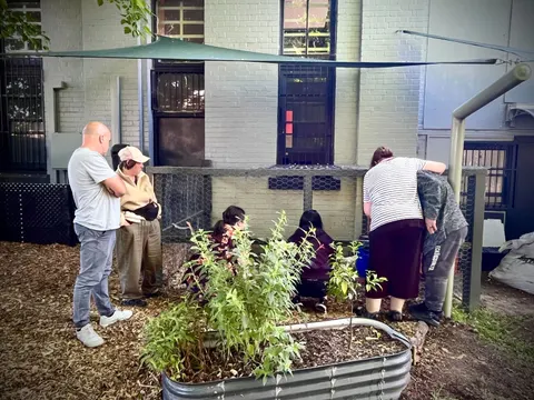 People planting in a raised garden bed