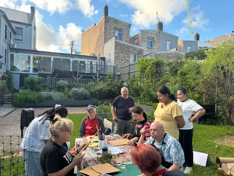 A group doing art and craft around a table in the garden